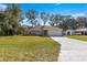 Newly built house showcasing a gray exterior, white garage door, and a spacious front yard at 7084 Se 124 St, Belleview, FL 34420