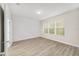 Bright bedroom with large window, vinyl flooring, and modern wall detail at 7402 Sw 99Th Ave, Ocala, FL 34481