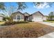 Gray house with white garage door and landscaping, one-story home at 7402 Sw 99Th Ave, Ocala, FL 34481