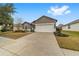 Gray house with white garage door and landscaping, one-story home at 7402 Sw 99Th Ave, Ocala, FL 34481