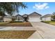 Gray house with white garage door and landscaping, one-story home at 7402 Sw 99Th Ave, Ocala, FL 34481