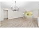 Bright living room featuring hardwood floors and a modern chandelier at 7402 Sw 99Th Ave, Ocala, FL 34481