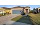 Tan one-story house with gray garage door, landscaped yard, and paver driveway at 7752 Sw 96Th Avenue Rd, Ocala, FL 34481