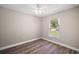 Well-lit bedroom with wood-look flooring and a window with backyard view at 8 Juniper Track Dr, Ocala, FL 34480