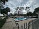 Community pool area with lounge chairs and surrounding fence at 8241 Fairways Cir # E102, Ocala, FL 34472