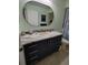 Bathroom boasting a granite countertop, dark vanity, and oval mirror at 8623 Sw 108Th Place Rd, Ocala, FL 34481