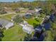 Aerial view showcasing home, pool, canal access, and lush landscaping at 11418 Lake Eustis Dr, Leesburg, FL 34788