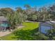 Spacious backyard with a shed, lush lawn, and canal view at 11418 Lake Eustis Dr, Leesburg, FL 34788