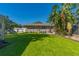 Large backyard with lush lawn and tropical landscaping at 11418 Lake Eustis Dr, Leesburg, FL 34788