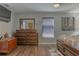 Main bedroom with dresser, hardwood floors, and large artwork at 11418 Lake Eustis Dr, Leesburg, FL 34788