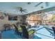 Covered patio with pool access, comfortable seating, and a TV at 11418 Lake Eustis Dr, Leesburg, FL 34788
