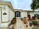 Home entrance features decorative door, patterned walkway, and professionally landscaped garden at 15715 Sw 11Th Terrace Rd, Ocala, FL 34473