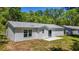 Back exterior view of the home featuring yard and white siding at 16434 Se 57 Pl, Ocklawaha, FL 32179