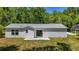 Back of home with white siding, a sliding glass door, and a compact concrete patio at 16434 Se 57 Pl, Ocklawaha, FL 32179