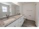Bathroom featuring double sink vanity, granite countertop, and tile shower at 16434 Se 57 Pl, Ocklawaha, FL 32179