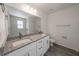 Bathroom featuring double sink vanity, granite countertop, and tile shower at 16434 Se 57 Pl, Ocklawaha, FL 32179