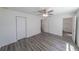 Bedroom with gray wood floors, ceiling fan, and a view into bathroom at 16434 Se 57 Pl, Ocklawaha, FL 32179
