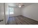 Bright bedroom featuring wood-look floors, a ceiling fan, and a window at 16434 Se 57 Pl, Ocklawaha, FL 32179