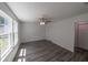 Bright bedroom featuring gray wood floors, a ceiling fan, and a closet at 16434 Se 57 Pl, Ocklawaha, FL 32179