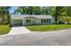 Cozy one-story home with a convenient carport, manicured lawn, and a welcoming facade at 16434 Se 57 Pl, Ocklawaha, FL 32179
