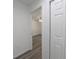 Hallway featuring gray floors and view into bedroom at 16434 Se 57 Pl, Ocklawaha, FL 32179