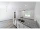 Open concept kitchen and living area with granite countertops, stainless steel appliances, and ample light at 16434 Se 57 Pl, Ocklawaha, FL 32179
