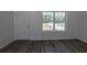 Living room showing front door, window, and gray wood-look floors at 16434 Se 57 Pl, Ocklawaha, FL 32179