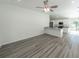 Open-concept living area with wood-look flooring, seamlessly connected to a modern kitchen at 16434 Se 57 Pl, Ocklawaha, FL 32179