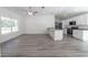 Open floor plan with new gray floors, kitchen island, and stainless appliances at 16434 Se 57 Pl, Ocklawaha, FL 32179