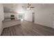 Spacious living room with wood-look flooring, flowing into a kitchen with white cabinets at 16434 Se 57 Pl, Ocklawaha, FL 32179