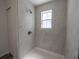 Shower features white marble tile, window, and a showerhead at 16434 Se 57 Pl, Ocklawaha, FL 32179