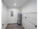 Efficient utility room with modern water heater, shelving, and durable wood-look flooring at 16434 Se 57 Pl, Ocklawaha, FL 32179