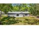 Beautiful backyard with a gray house, sliding glass door, and lush green grass at 16450 Se 57Th Pl, Ocklawaha, FL 32179