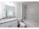 Well-lit bathroom with tiled shower/tub, granite-topped vanity, and neutral color palette at 16450 Se 57Th Pl, Ocklawaha, FL 32179