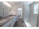Updated bathroom featuring double sinks, granite countertop, and tiled walk-in shower at 16450 Se 57Th Pl, Ocklawaha, FL 32179