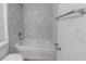 Close-up of white tiled shower and tub combination and granite vanity in bathroom at 16450 Se 57Th Pl, Ocklawaha, FL 32179