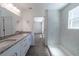 Updated bathroom featuring double sinks with granite countertops, and a tiled walk-in shower at 16450 Se 57Th Pl, Ocklawaha, FL 32179