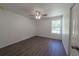 Bedroom features sleek ceiling fan, wood-look flooring, and sun-filled window at 16450 Se 57Th Pl, Ocklawaha, FL 32179