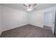Bedroom featuring sleek ceiling fan and wood-look flooring and open entry to bathroom at 16450 Se 57Th Pl, Ocklawaha, FL 32179