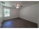 Bedroom featuring sleek ceiling fan, wood-look flooring, and sun-filled window at 16450 Se 57Th Pl, Ocklawaha, FL 32179