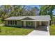 Charming single-story home with a well-manicured lawn, covered entry, and a convenient covered carport at 16450 Se 57Th Pl, Ocklawaha, FL 32179