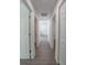 Hallway showcases open door to bathroom, wood-look floors, and white walls at 16450 Se 57Th Pl, Ocklawaha, FL 32179