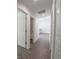 Hallway showcases open door to bathroom, wood-look floors, and white walls at 16450 Se 57Th Pl, Ocklawaha, FL 32179
