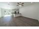 Open-concept living area with wood-look flooring, bright lighting, and a modern kitchen at 16450 Se 57Th Pl, Ocklawaha, FL 32179