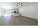 Open-concept living area with wood-look flooring, bright lighting, and a modern kitchen at 16450 Se 57Th Pl, Ocklawaha, FL 32179