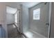 Bathroom features a walk-in shower with tile walls, and a view into the bedroom at 16450 Se 57Th Pl, Ocklawaha, FL 32179