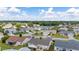 Aerial view of a residential neighborhood showcasing houses, trees, and a partly cloudy sky at 17606 Se 93Rd Butler Ct, The Villages, FL 32162