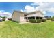 House's back with covered patio, grill, and manicured lawn at 17606 Se 93Rd Butler Ct, The Villages, FL 32162