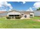House's back with covered patio, grill, and manicured lawn at 17606 Se 93Rd Butler Ct, The Villages, FL 32162