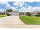 Two-car garage, spacious driveway, and nicely landscaped front yard at 17606 Se 93Rd Butler Ct, The Villages, FL 32162